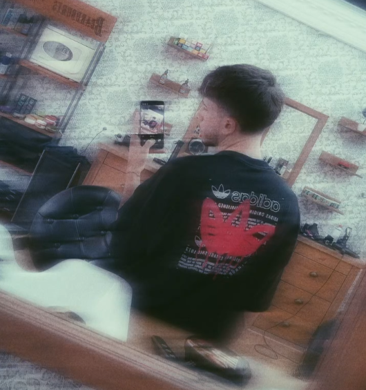 Pablo Olivares fotografiado ante el espejo de la barbería